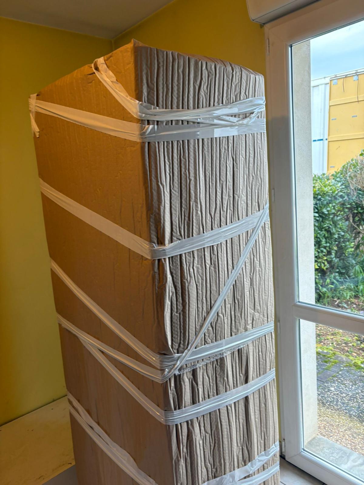 Armoire emballée dans du papier kraft et sécurisée par sangles
