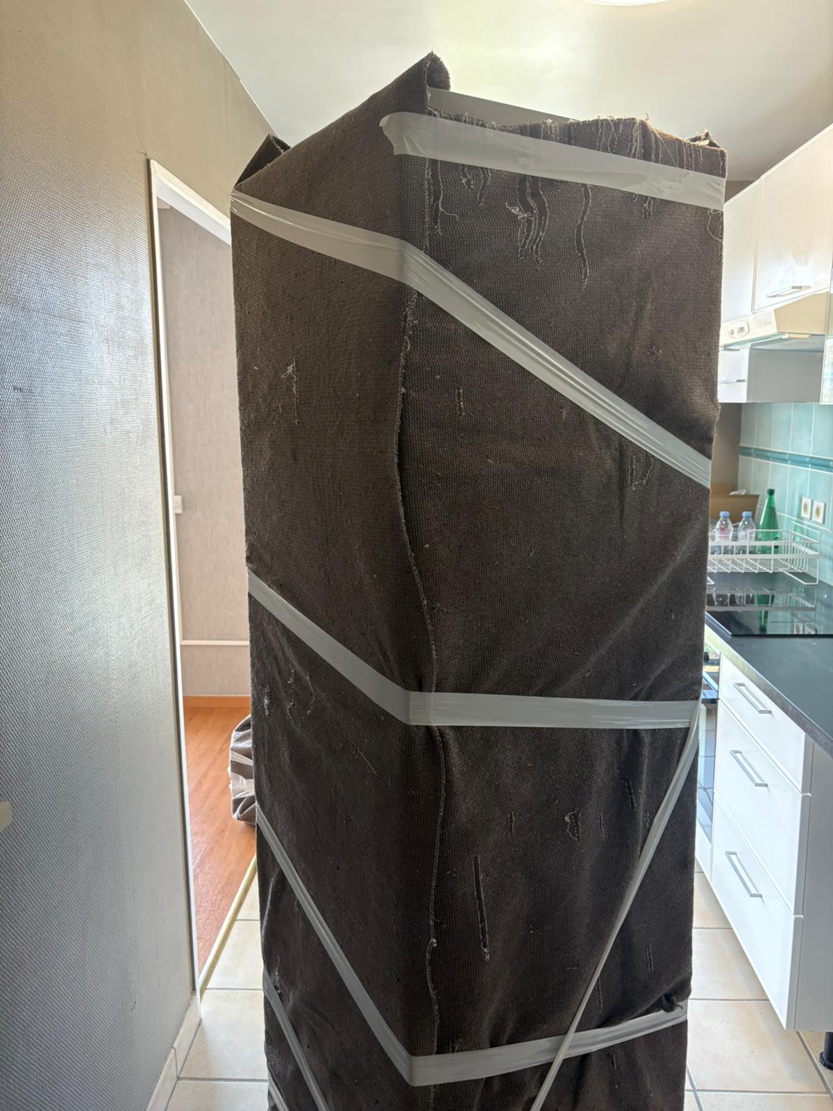 Armoire haute emballée sous couverture de protection