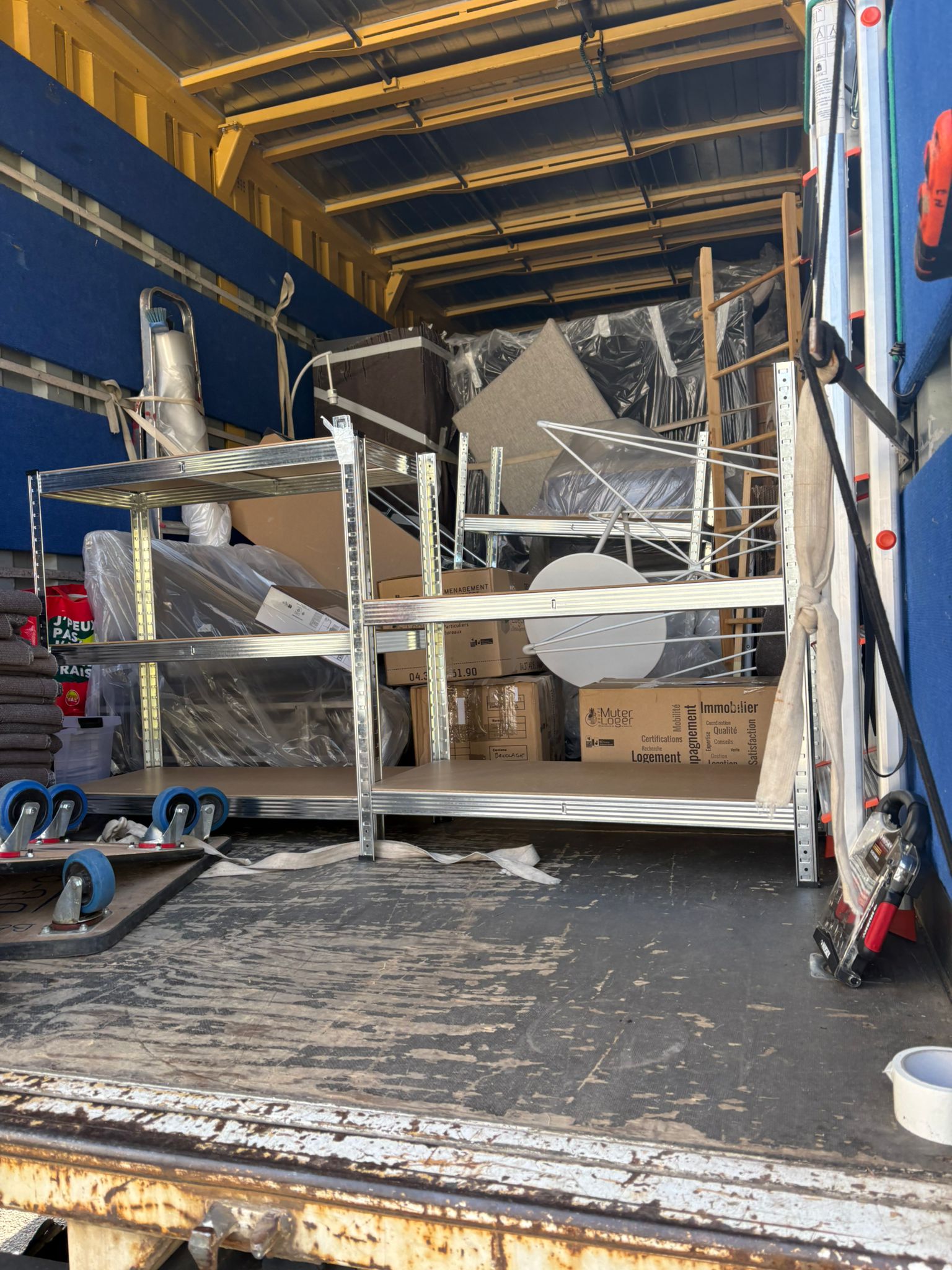Rayonnage métallique dans le camion EN PAYS WÊ stockant mobilier et électroménager